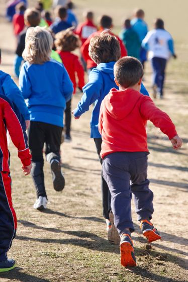 Primary pupils enjoying fun outdoor PE games in autumn